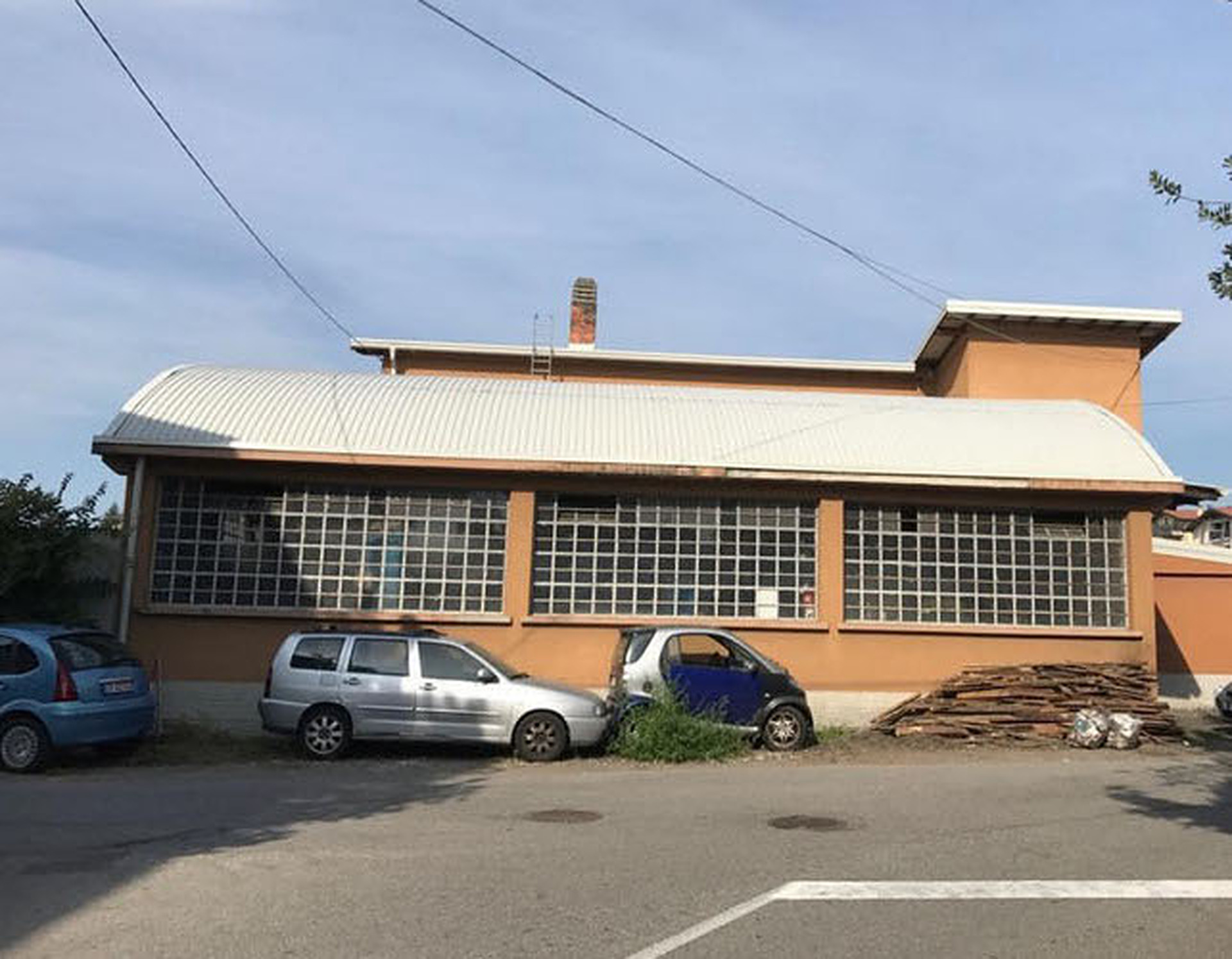 Capannone con la nuova copertura curva in lamiera chiara, dopo il rifacimento